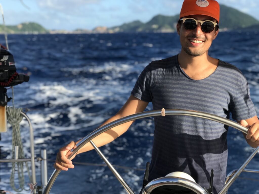 Un de nos clients à la barre au retour de l'excursion les saintes voile et snorkeling